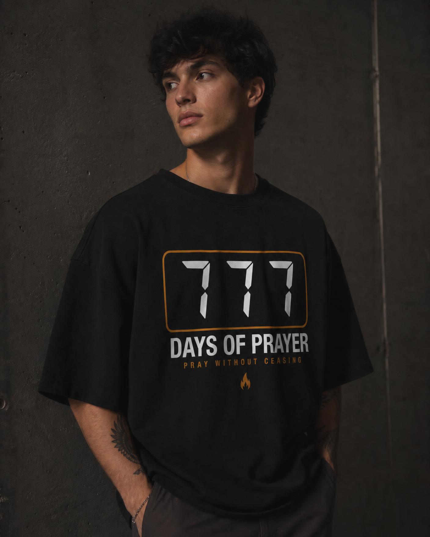 Model wearing the black 777 Days of Prayer heavyweight tee